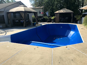 An empty pool in a residential backyard.